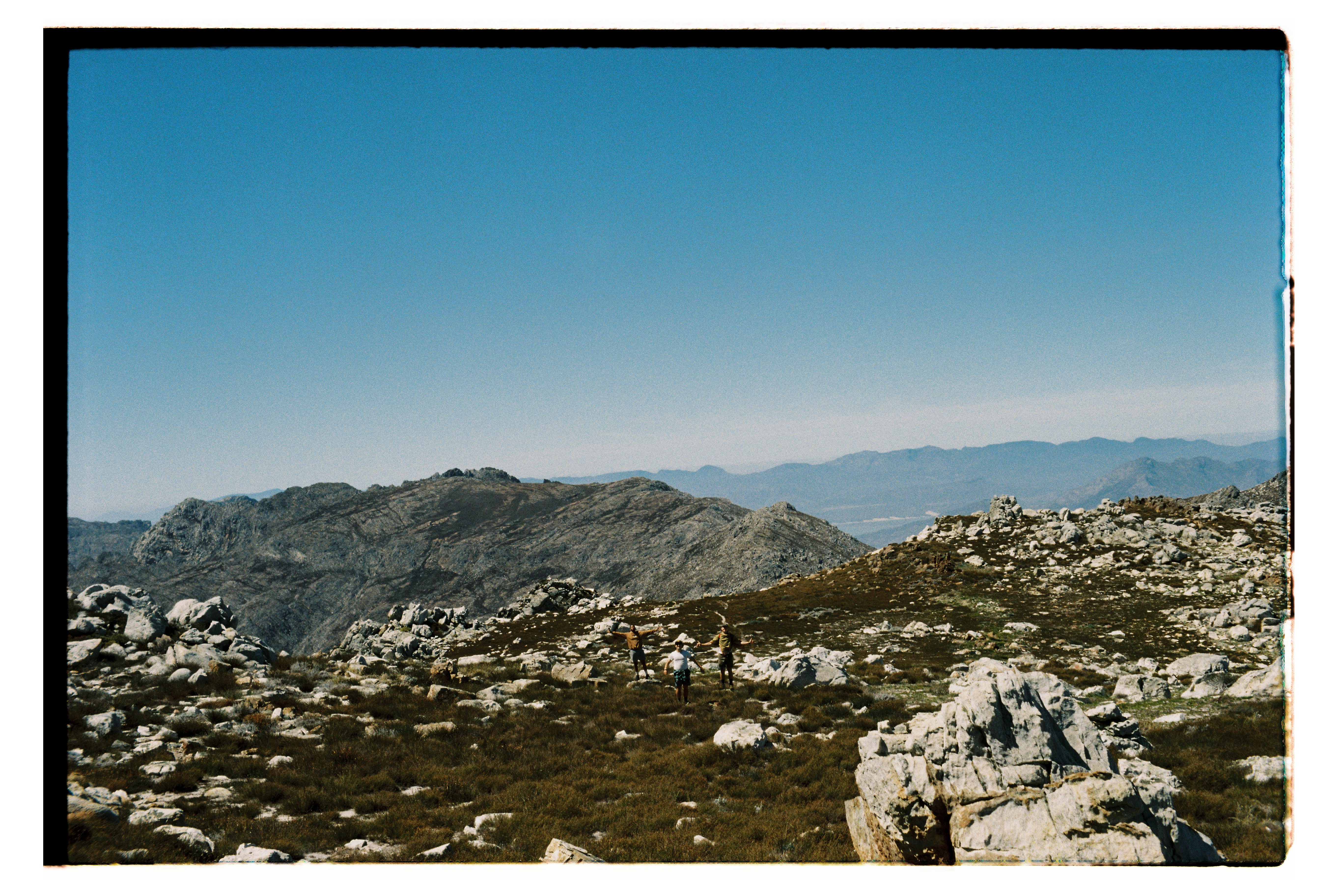 Three figures on a mountain.