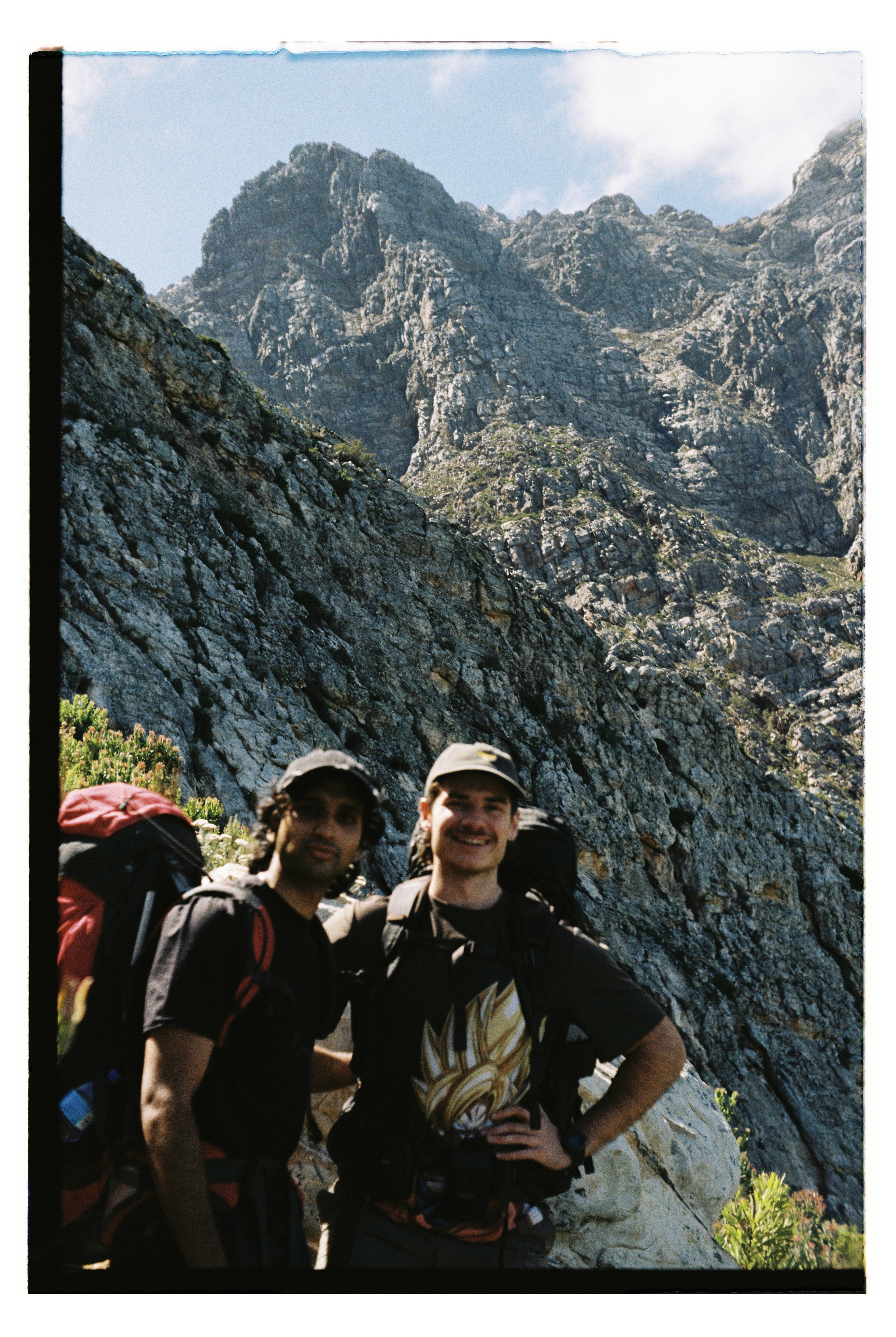 Two friends in front of a mountain.