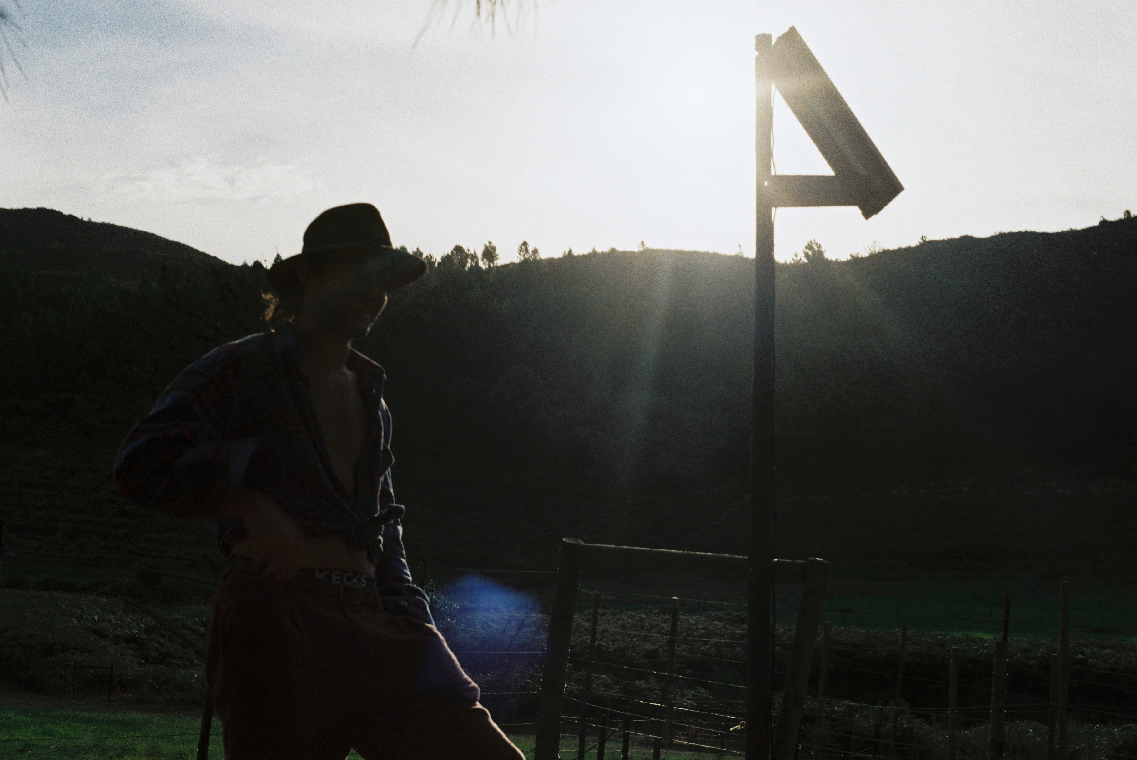 Cowboy looking to the fileds in sunset.
