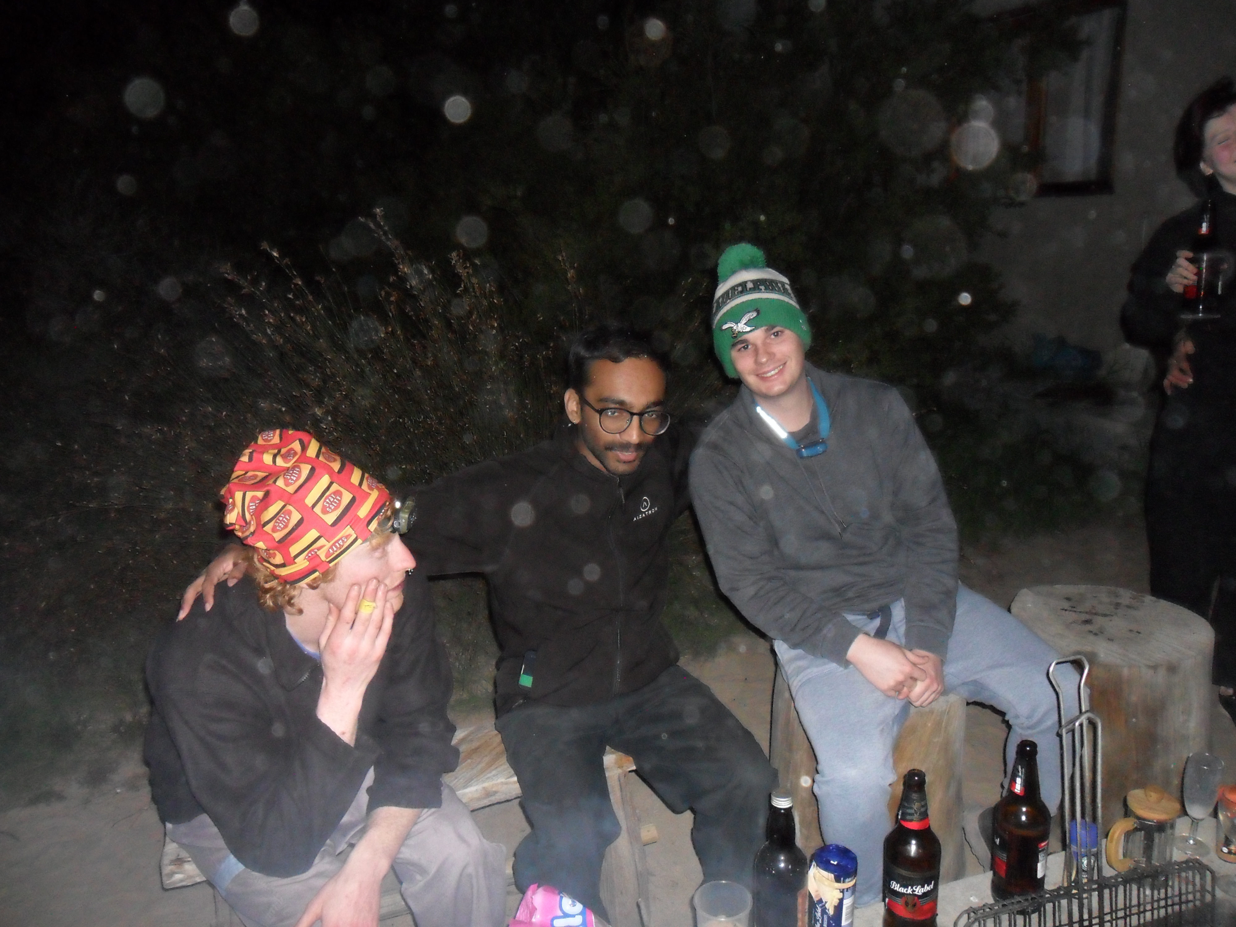 Three men around a campfire.
